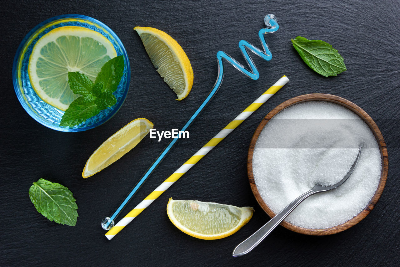 lemon, food and drink, food, citrus fruit, leaf, green, fruit, healthy eating, herb, wellbeing, directly above, no people, lime, indoors, freshness, citrus, studio shot, high angle view, mint leaf - culinary, slice, ingredient, plant part, wood, still life, yellow, nature, household equipment, black background, refreshment, spice