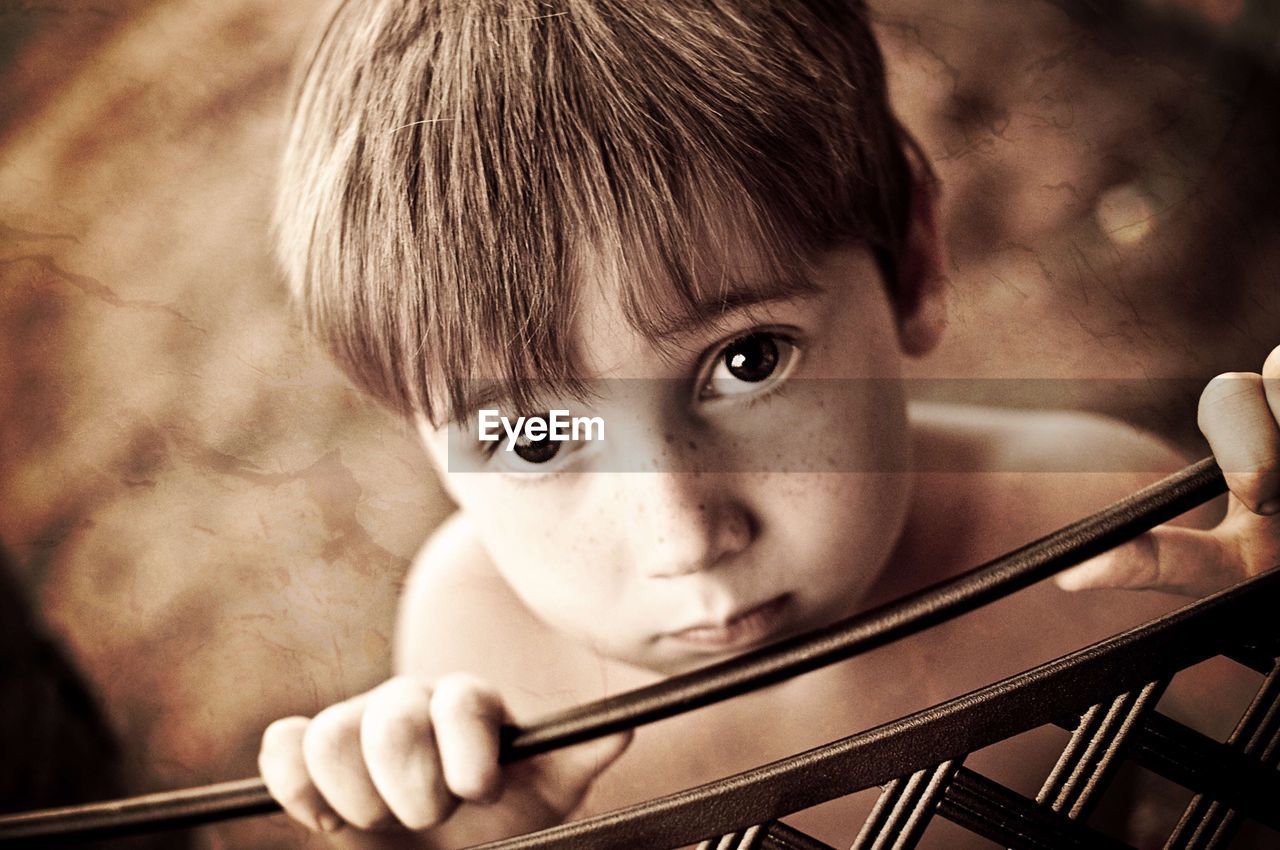 Portrait of boy standing by railing