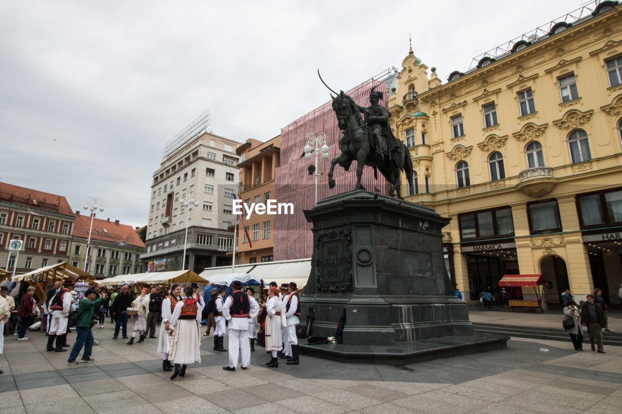 GROUP OF PEOPLE IN FRONT OF BUILDINGS