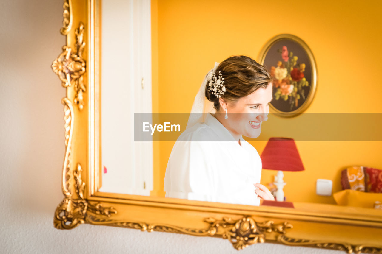 Reflection of smiling bride in mirror