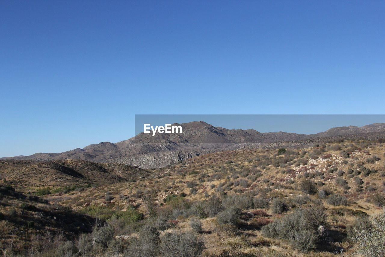 Scenic view of rocky mountains against clear blue sky