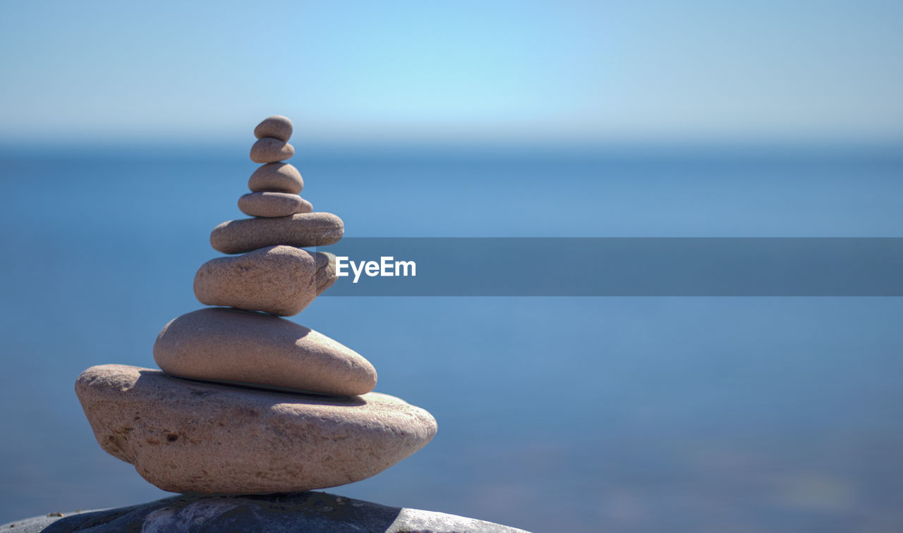 Close-up of stack of pebbles against calm sea