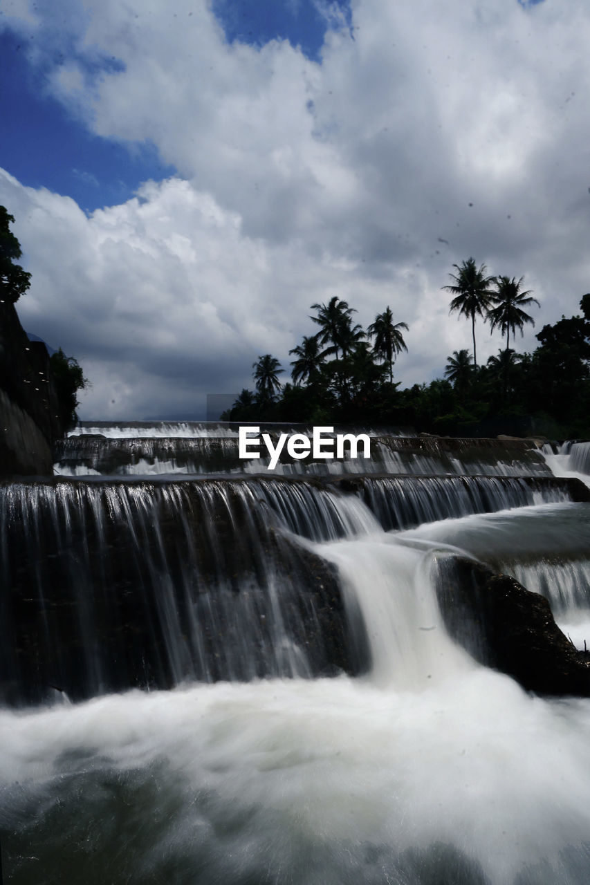 SCENIC VIEW OF WATERFALL AGAINST CLOUDY SKY