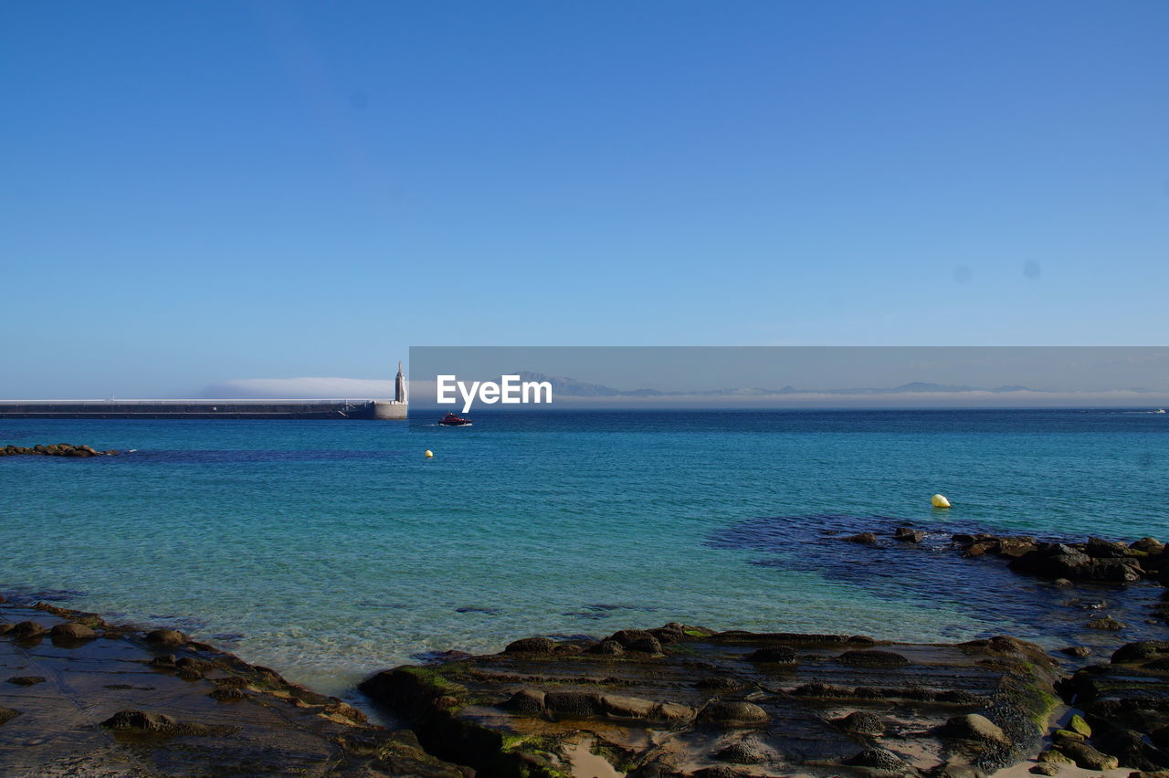 Scenic view of sea against clear blue sky