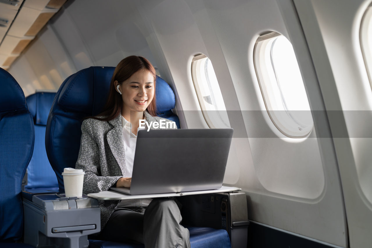 midsection of woman using laptop while sitting in car