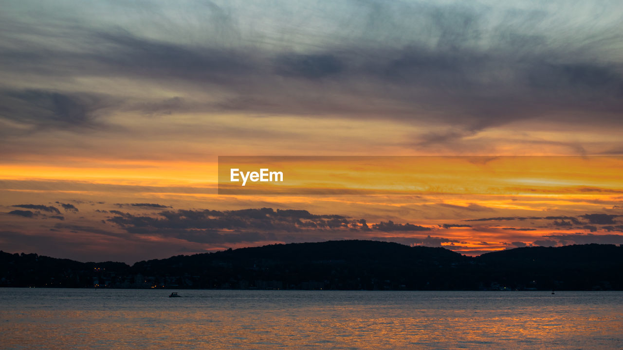 Scenic view of sea and mountains during sunset