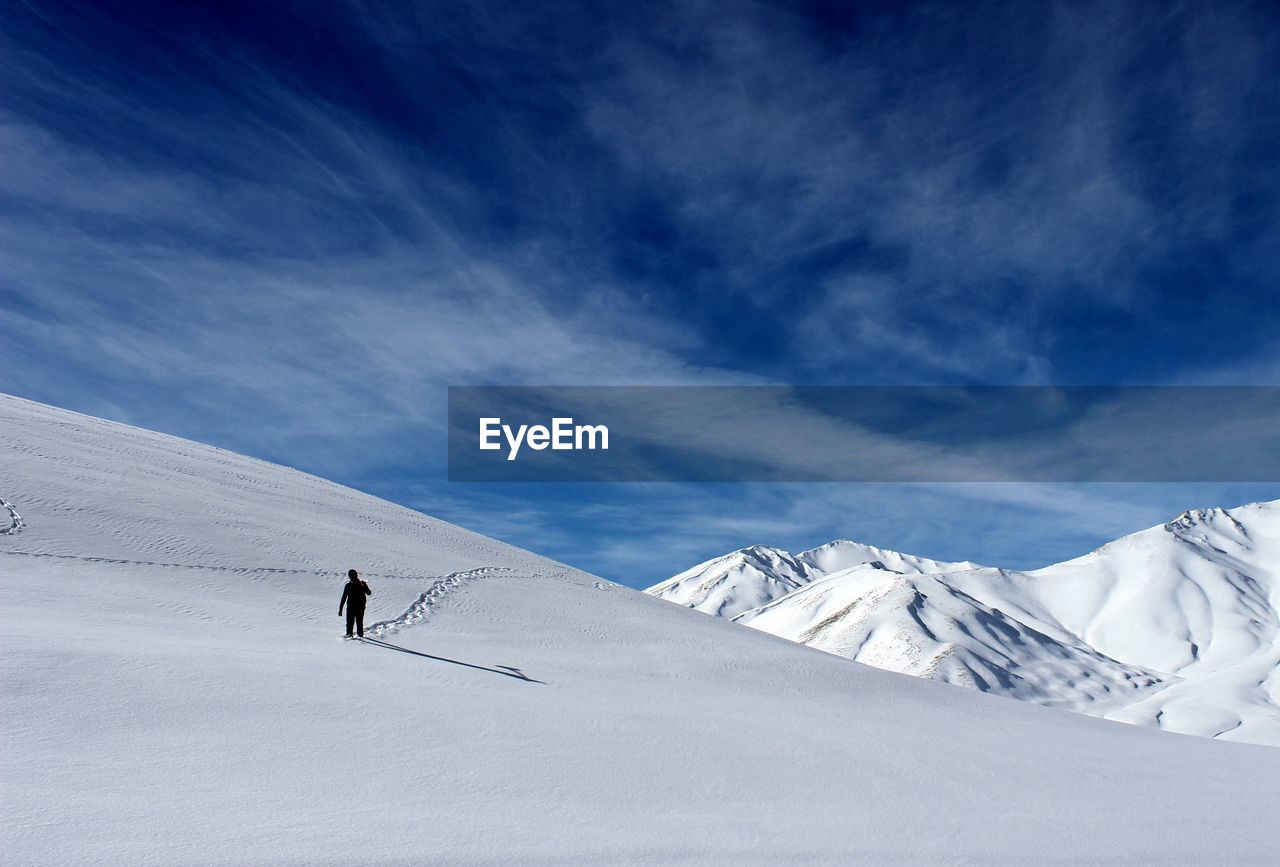 Man skiing on snowcapped mountain against sky