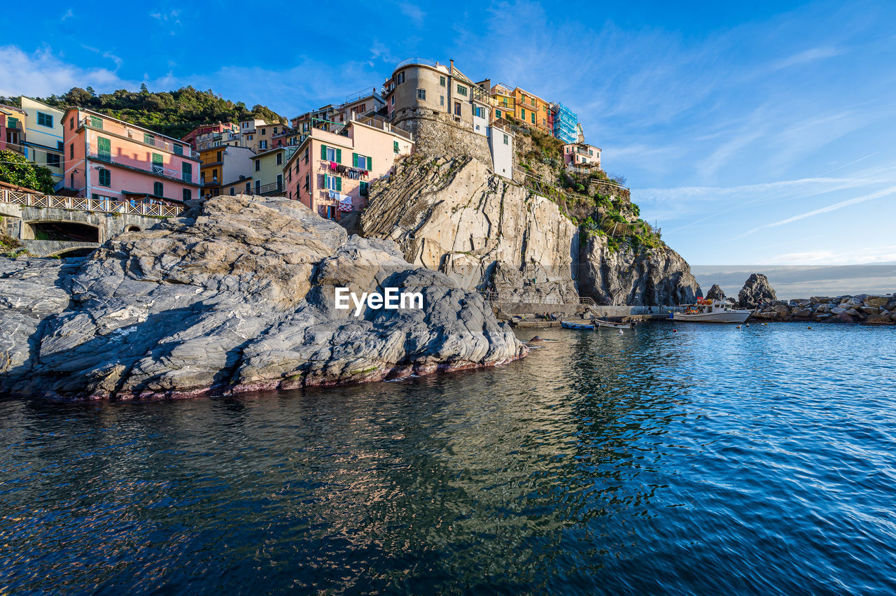 scenic view of sea by buildings against sky