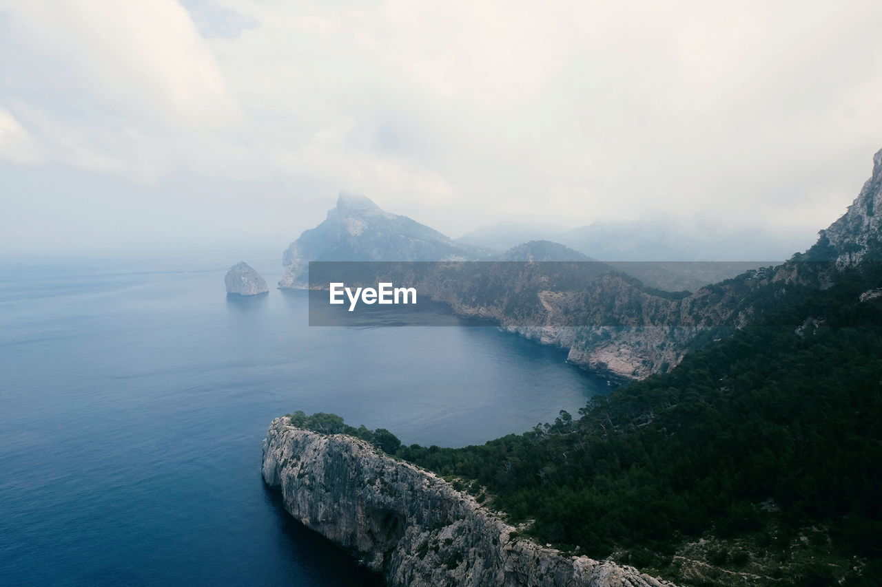 Scenic view of sea and mountains against sky