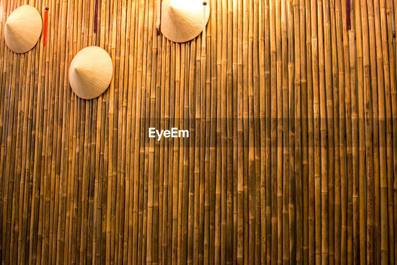 Low angle view of hats hanging on wooden wall