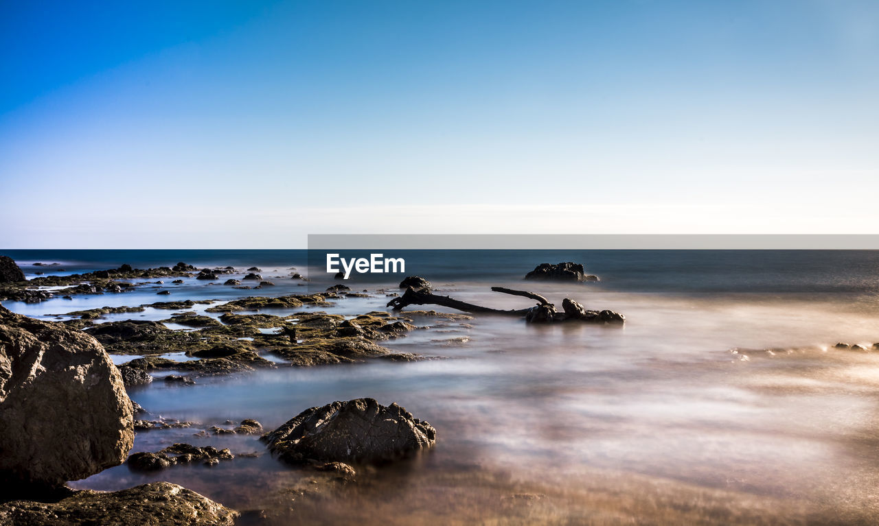 Scenic view of sea against clear blue sky