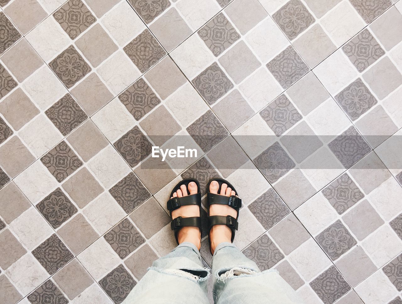 Low section of woman standing on tiled floor