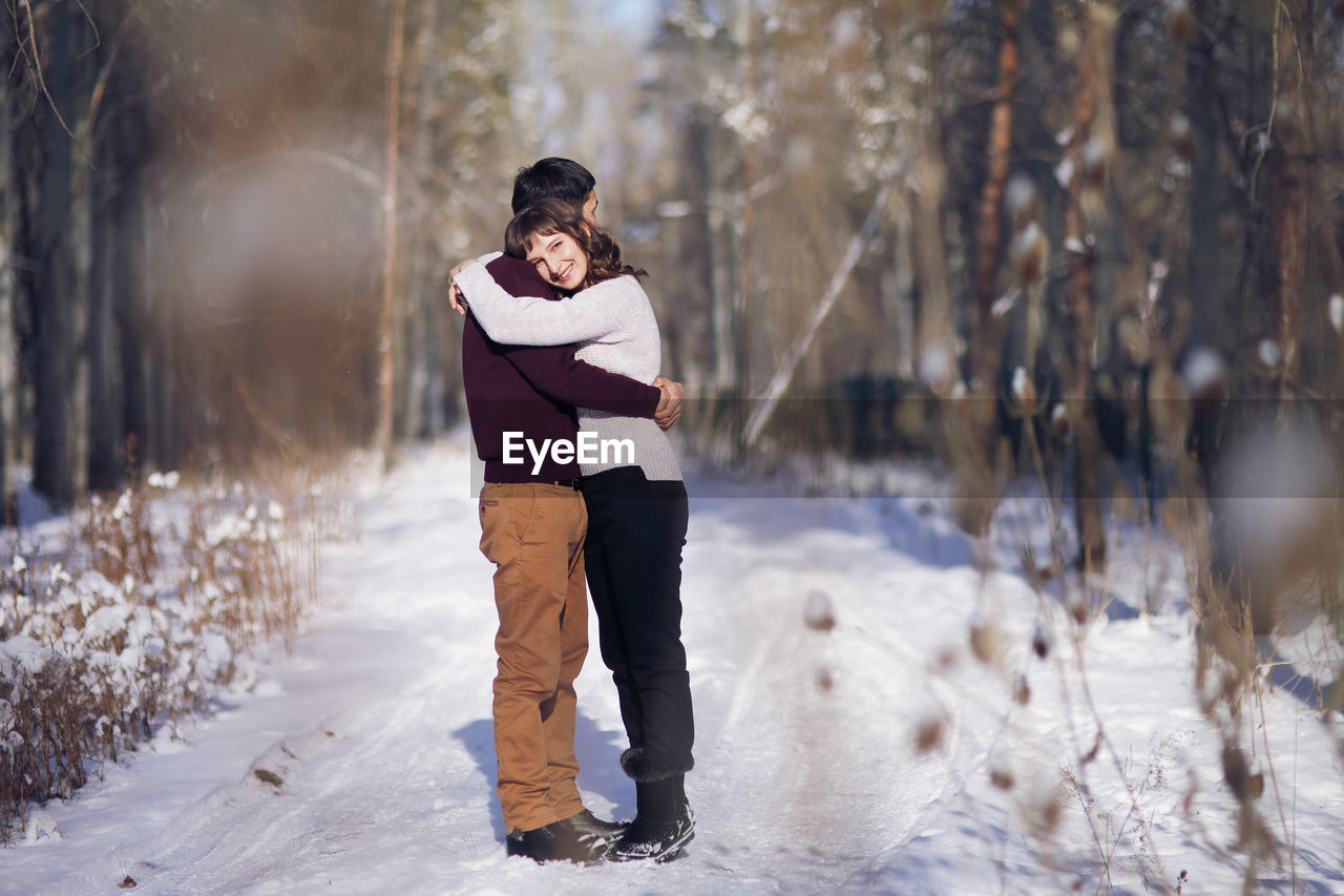 Full length of couple standing on snow covered land