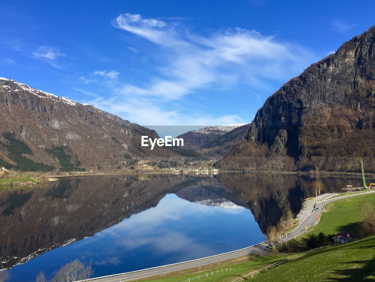 Scenic view of lake and mountains against blue sky