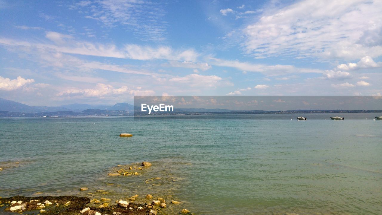 SCENIC VIEW OF SEA BY MOUNTAIN AGAINST SKY