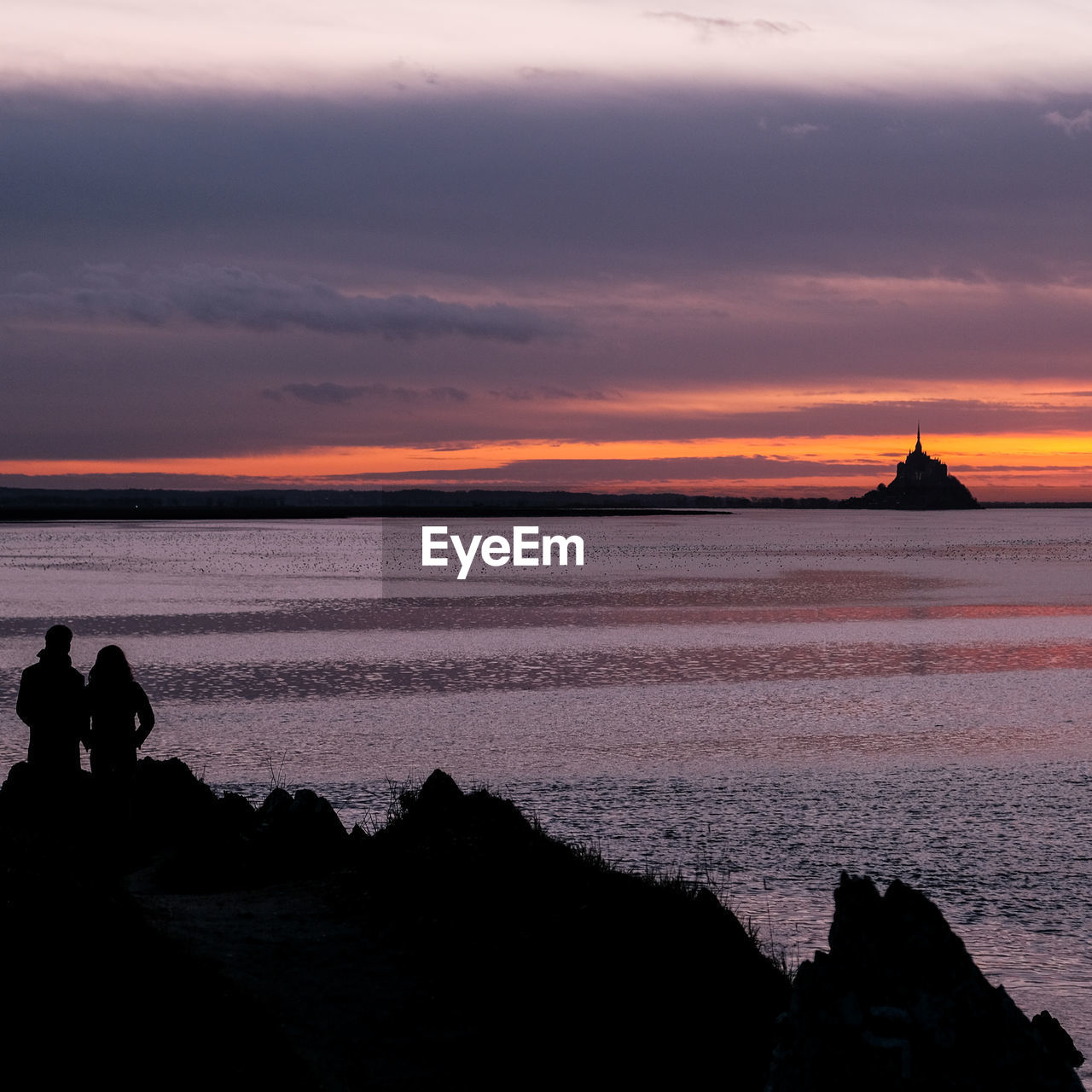 SILHOUETTE ROCKS ON SHORE AGAINST SKY DURING SUNSET