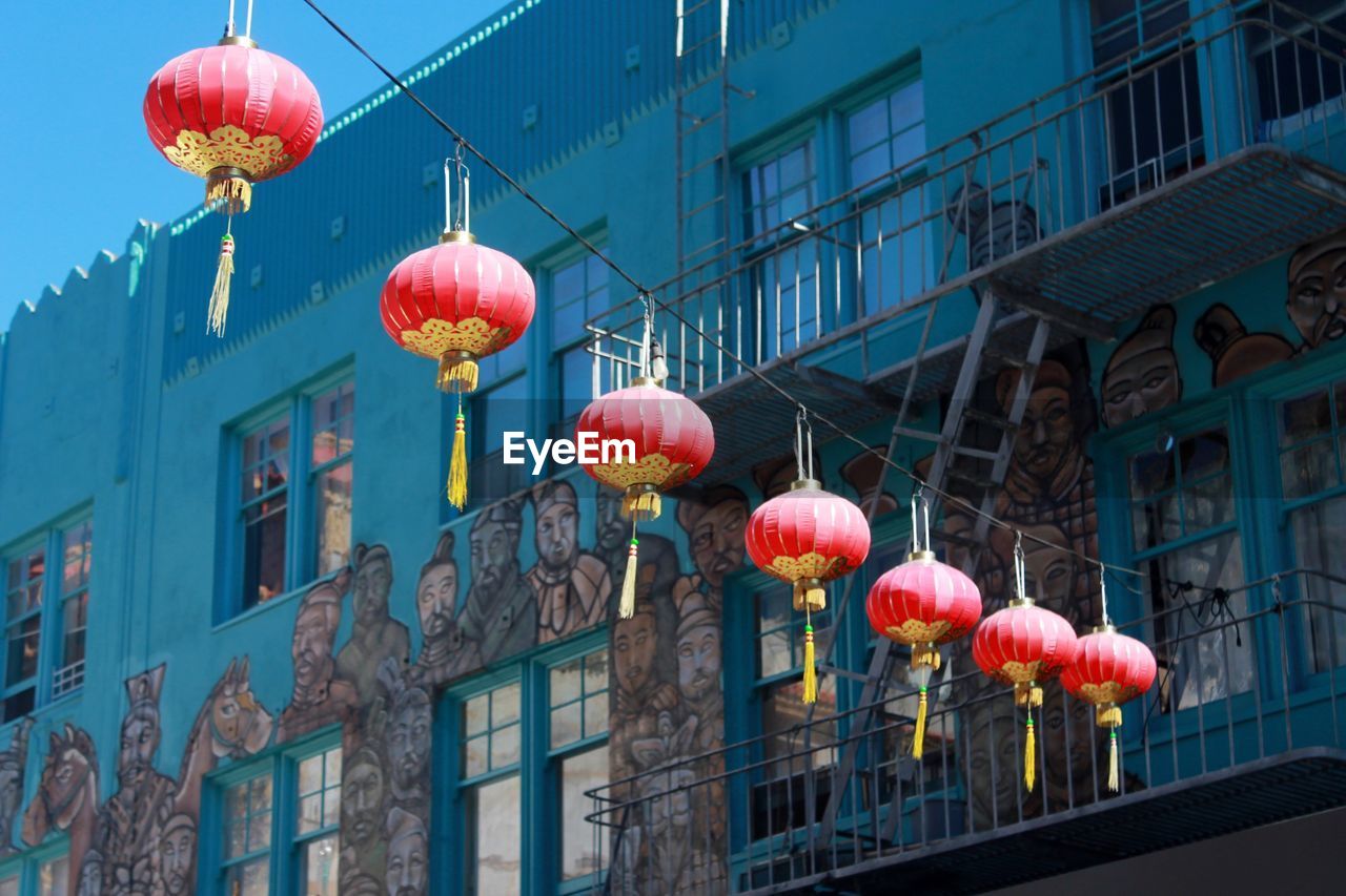 Low angle view of lantern against mural painting on building