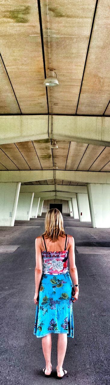 Rear view full length of woman standing below bridge