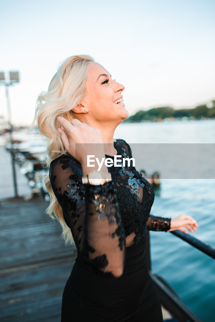 YOUNG WOMAN LOOKING AWAY AGAINST BOAT