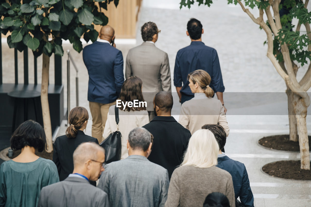 High angle view of male and female entrepreneurs walking outside office