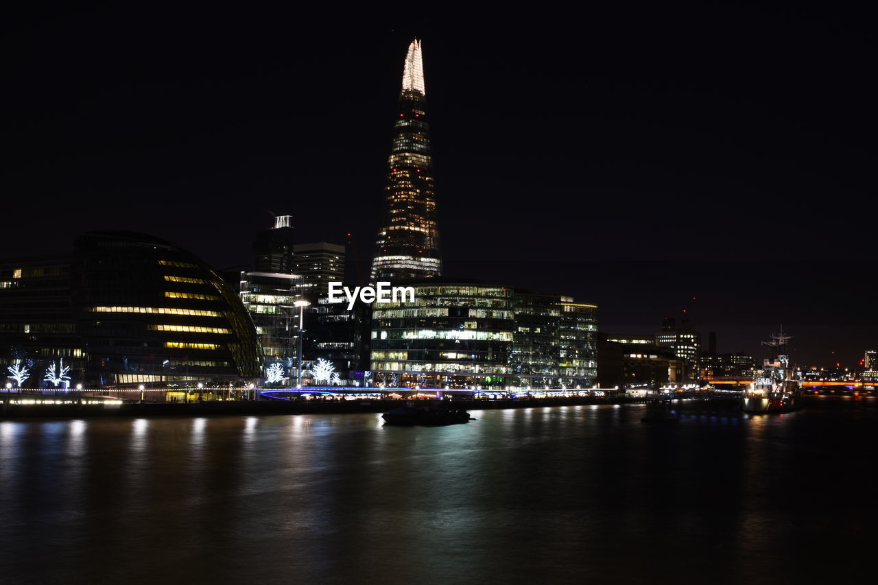 ILLUMINATED MODERN BUILDINGS AT WATERFRONT