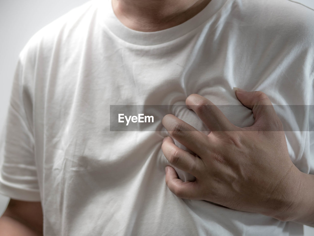 Midsection of man holding aching chest 
