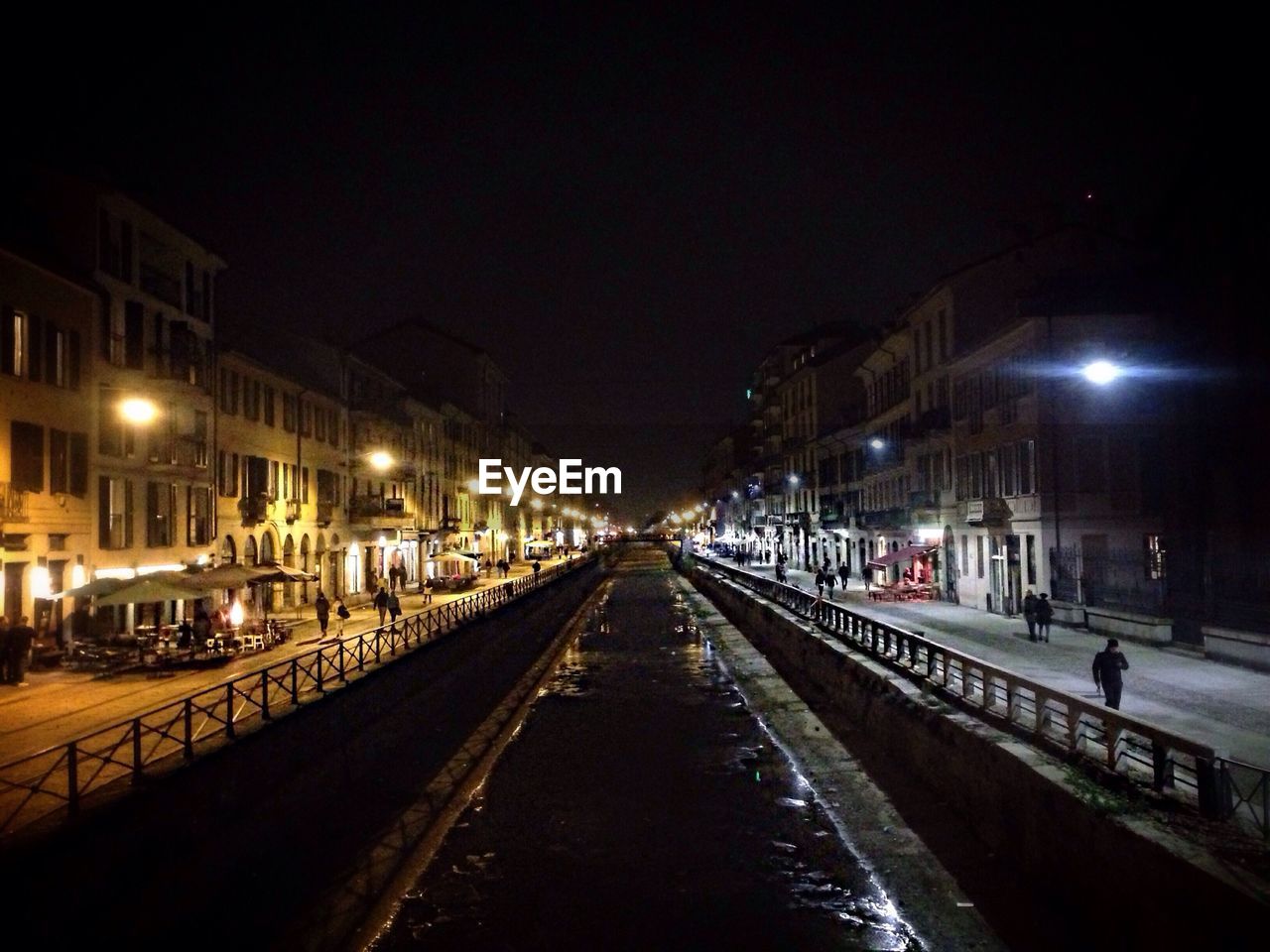 Canal amidst buildings against clear sky at night