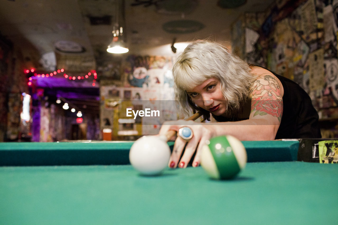Young woman playing pool