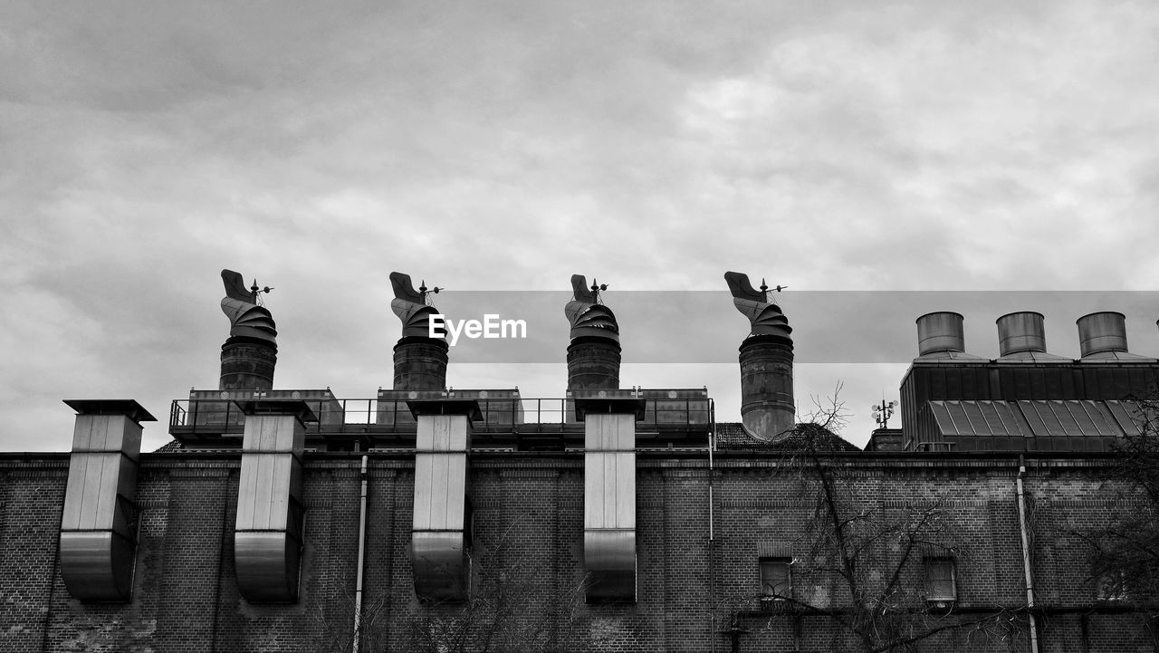 LOW ANGLE VIEW OF STATUES ON BUILDING AGAINST SKY