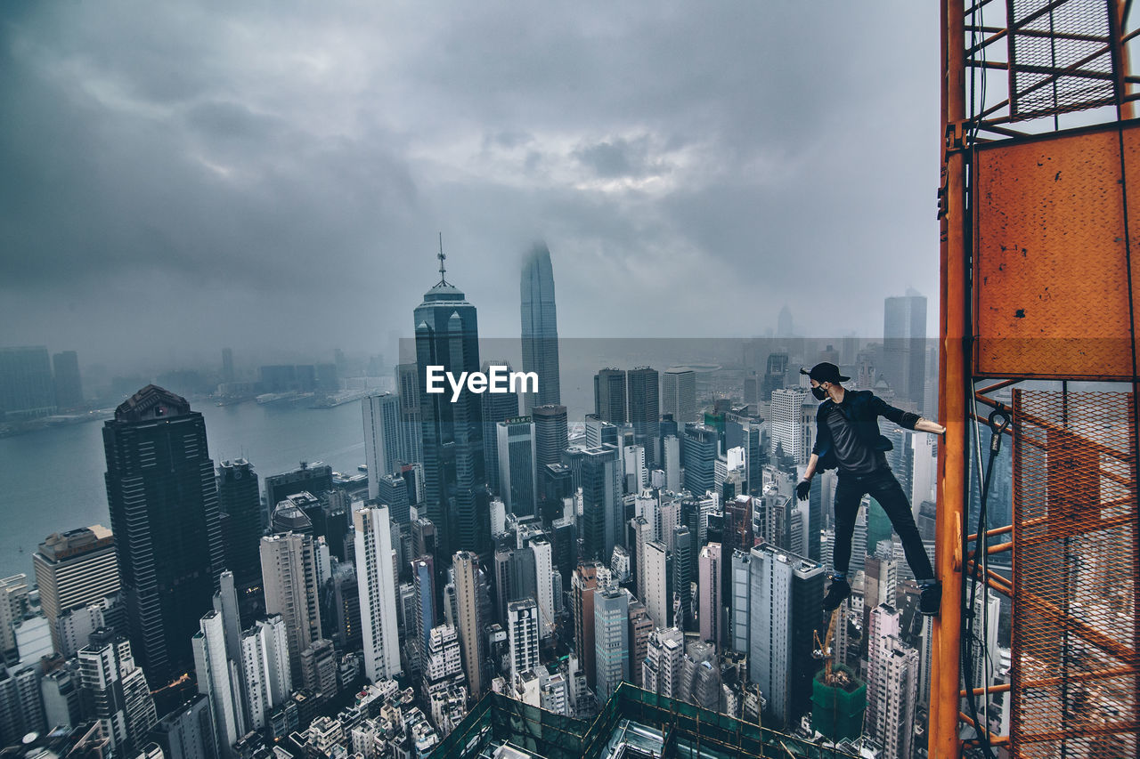 High angle shot of cityscape against clouds