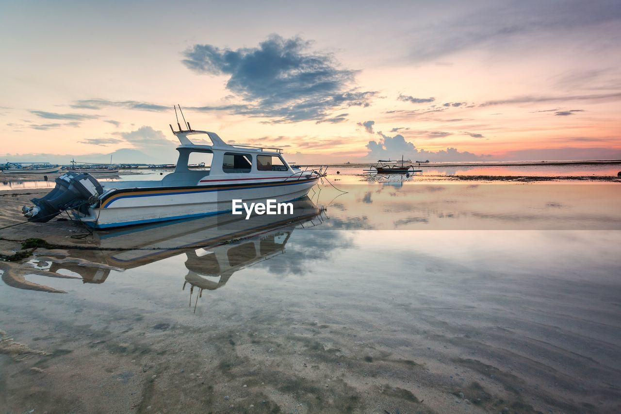 Boats in sea against sky during sunset