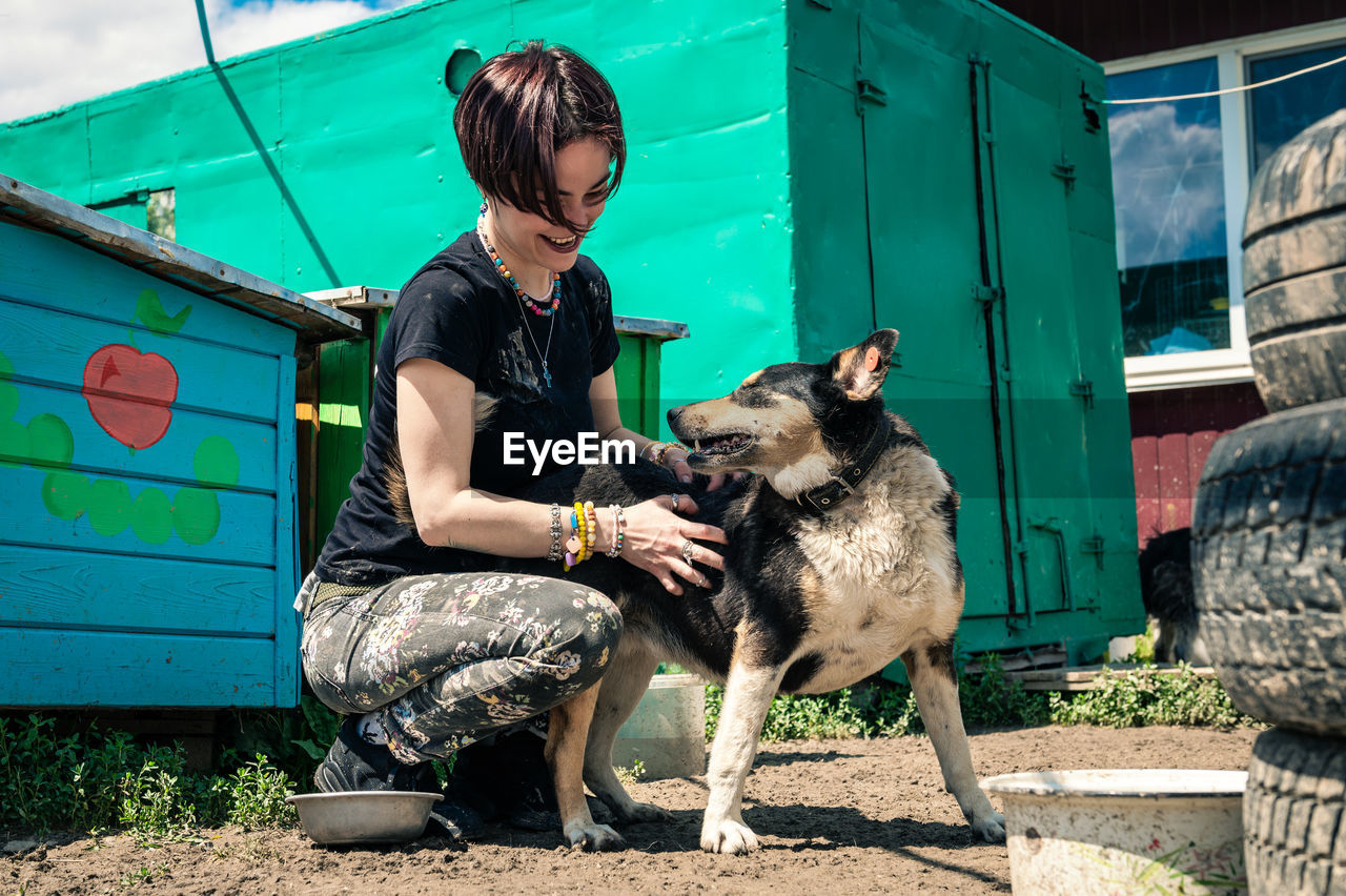 Dog at the shelter.  lonely dogs in cage with cheerful woman volunteer