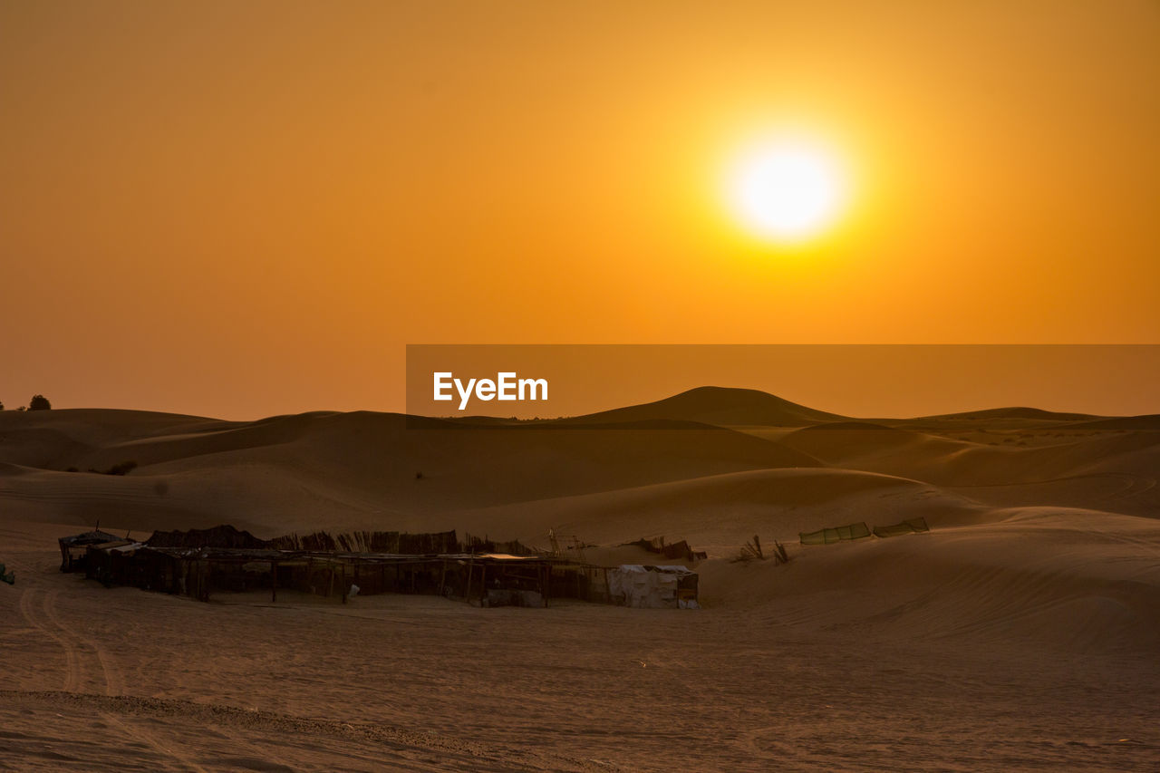 Scenic view of desert against sky during sunset