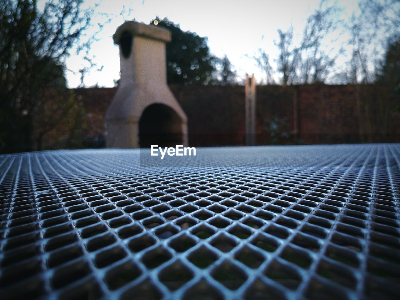 CLOSE-UP OF METAL GRATE ON TREE