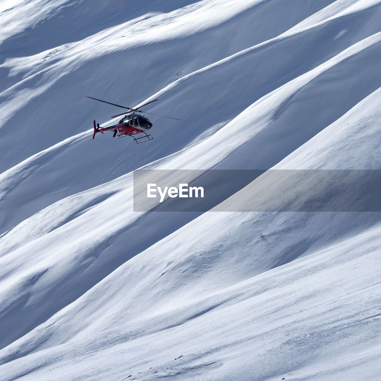 Helicopter flying by snowcapped mountain