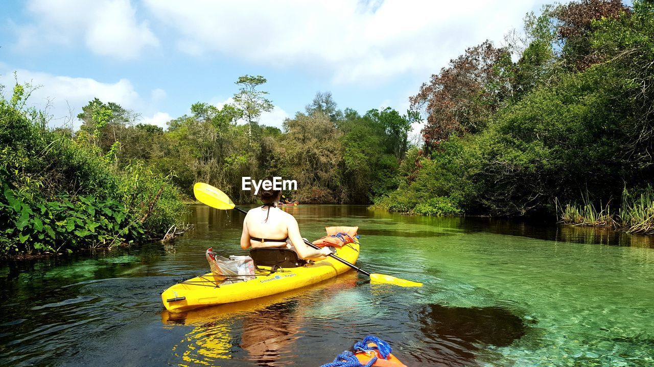 Rear view of woman kayaking on river