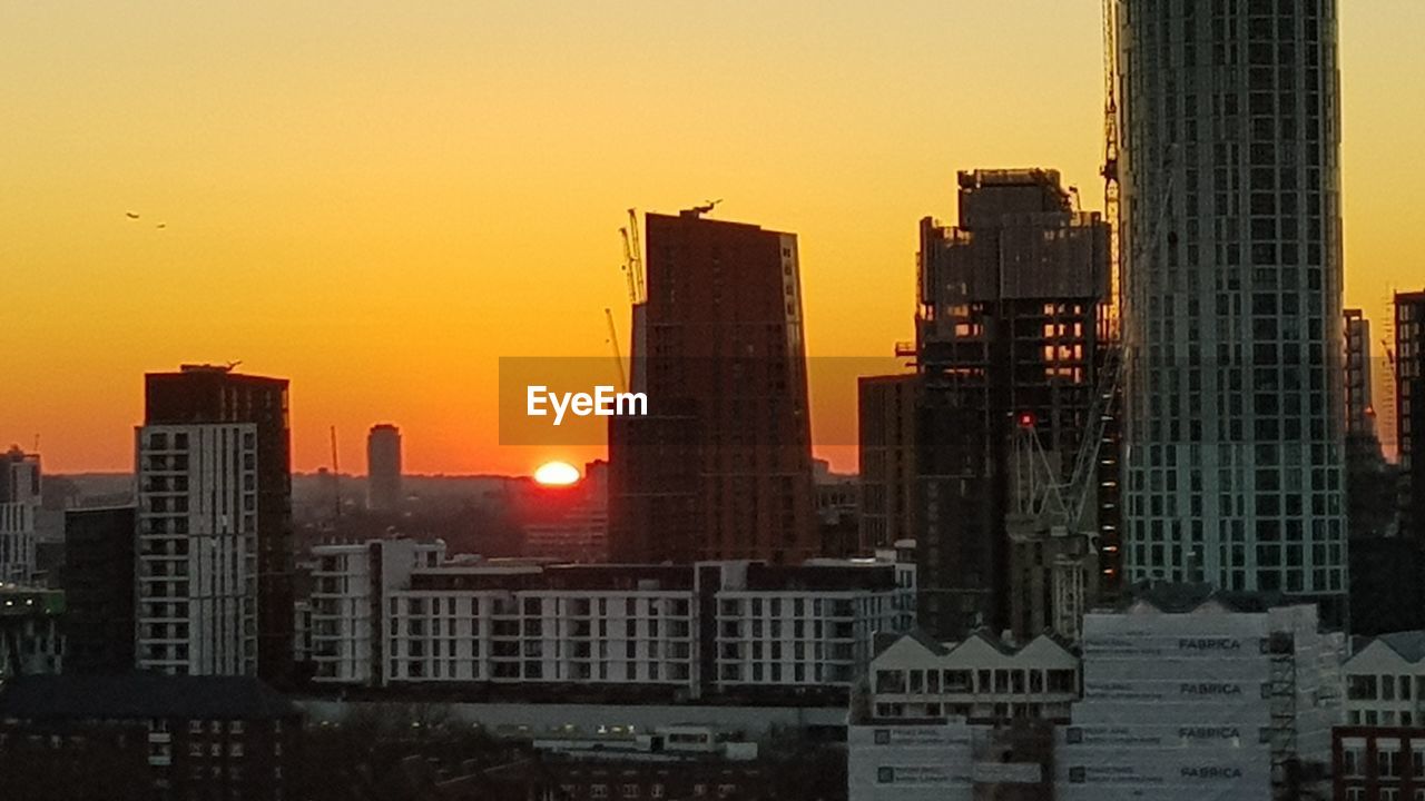 VIEW OF SKYSCRAPERS IN CITY DURING SUNSET