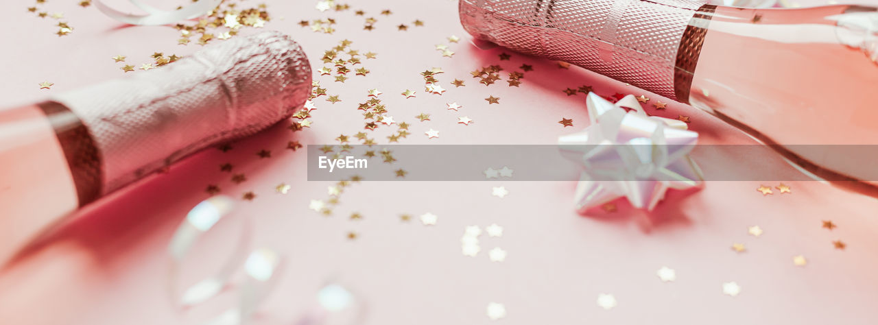 HIGH ANGLE VIEW OF PINK PETALS ON WHITE TABLE