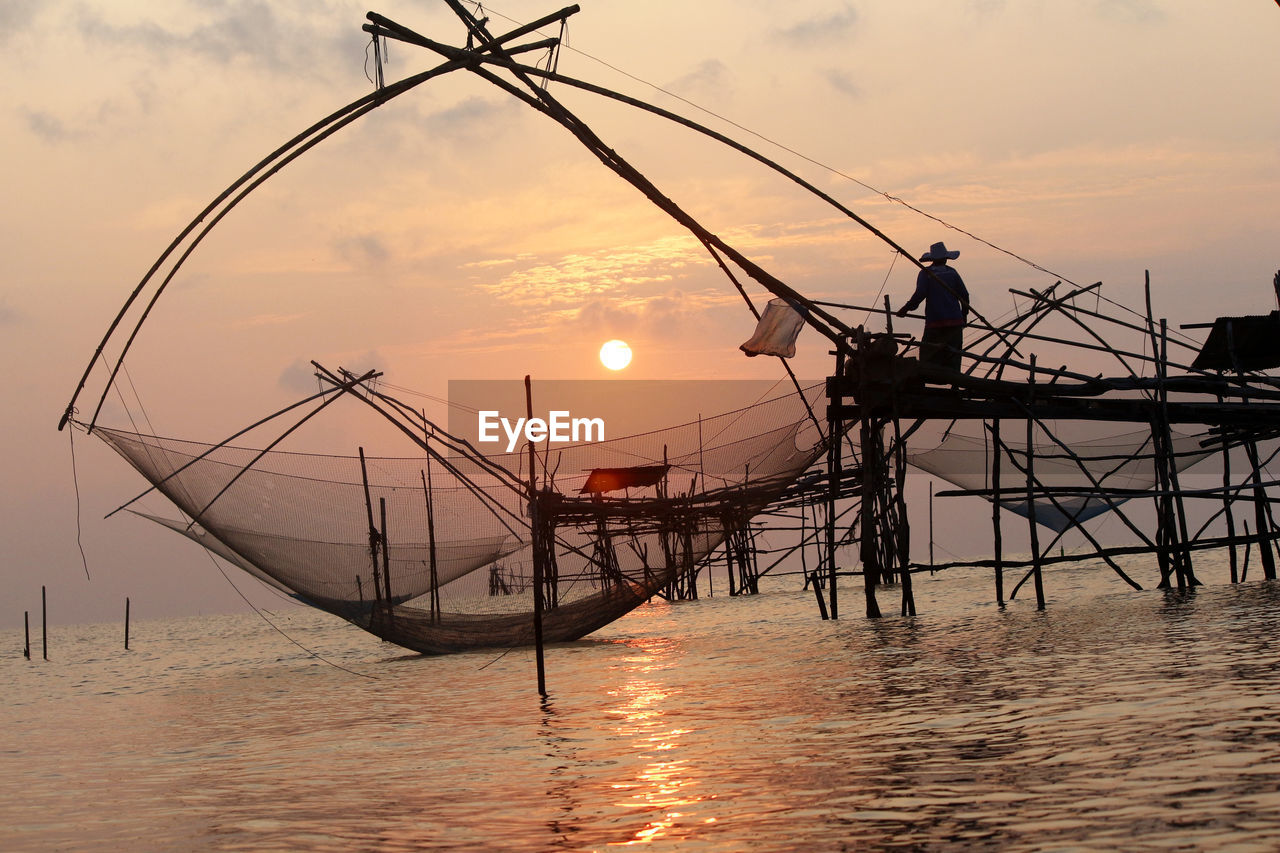 FISHING NET IN SEA DURING SUNSET