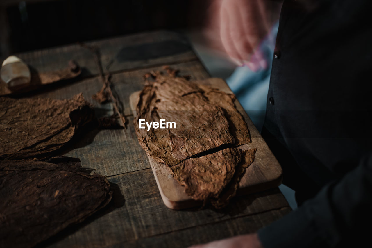 HIGH ANGLE VIEW OF PERSON PREPARING MEAT