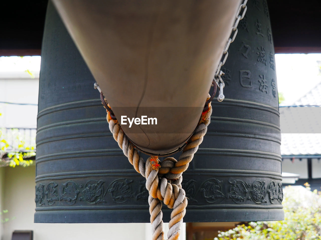 Rope tied to metallic bell at japanese temple