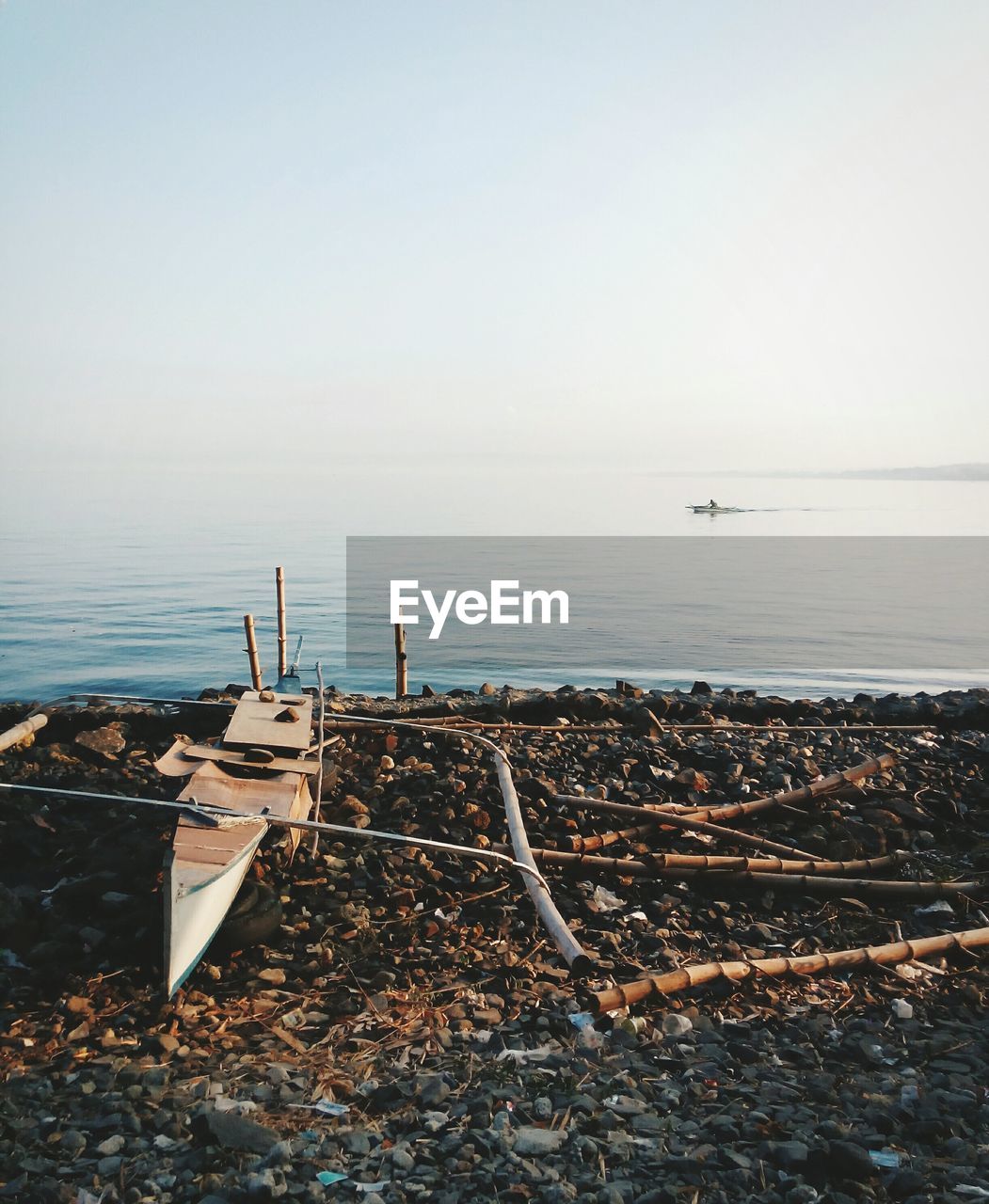 High angle view of broken boat on field by sea against clear sky