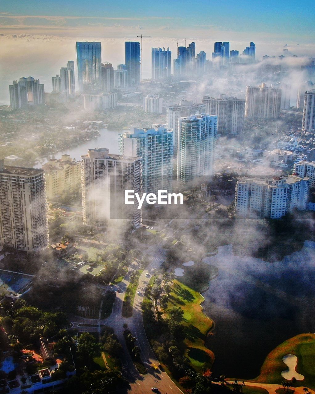 HIGH ANGLE VIEW OF BUILDINGS AGAINST SKY IN CITY