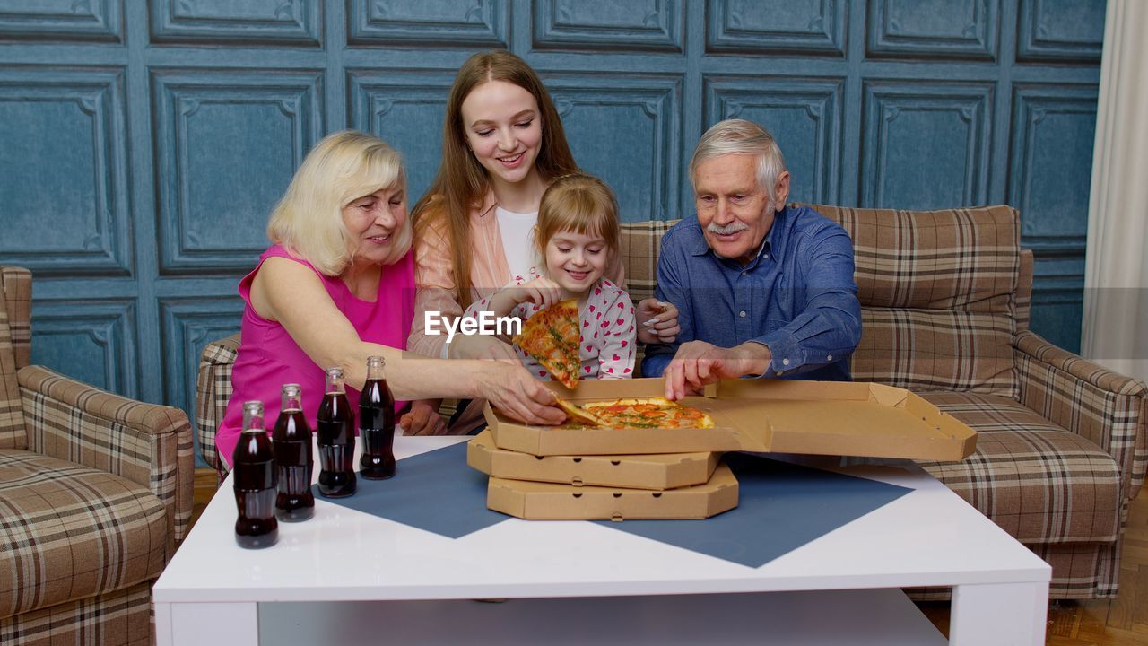 portrait of smiling family sitting on table