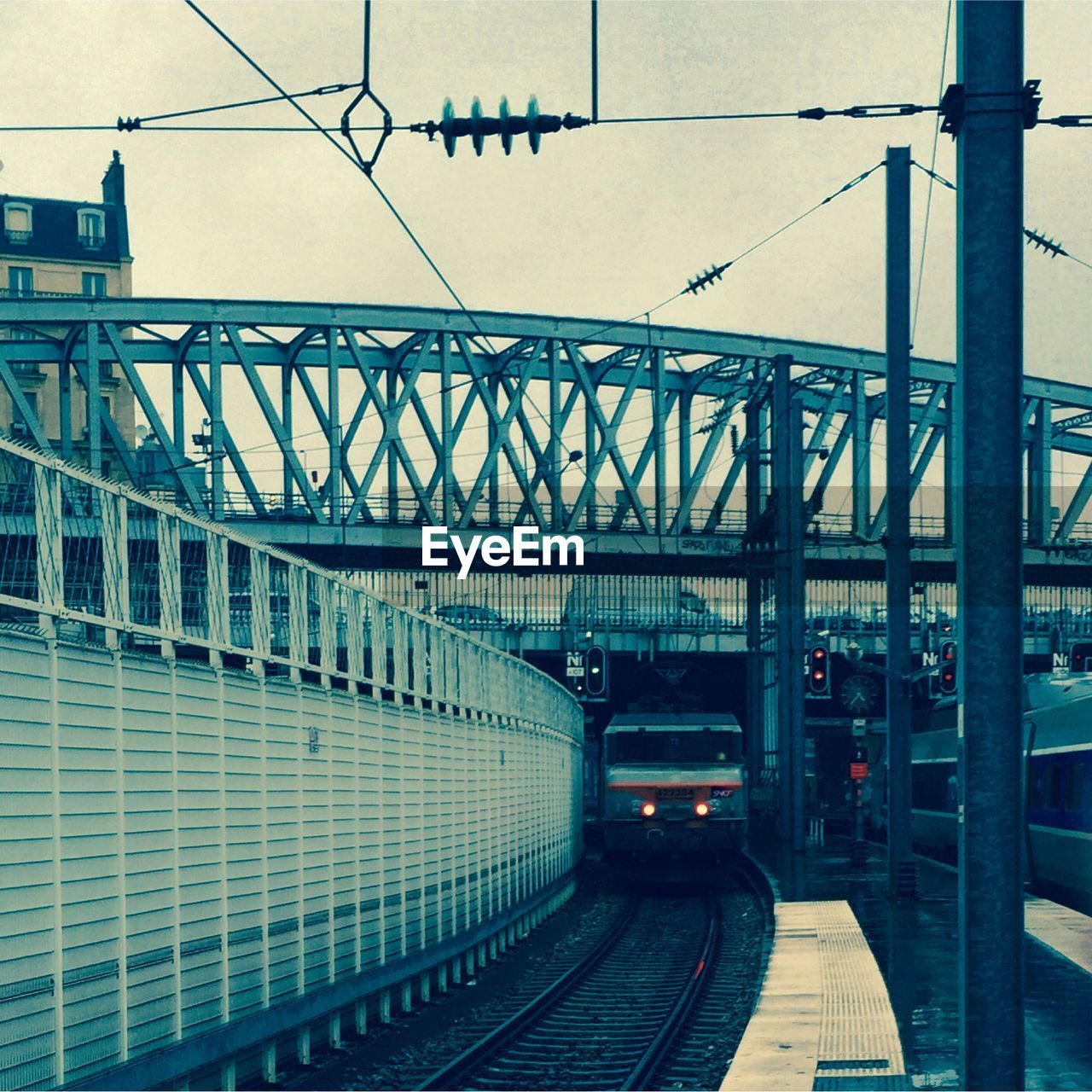 Trains at railroad station against sky in city