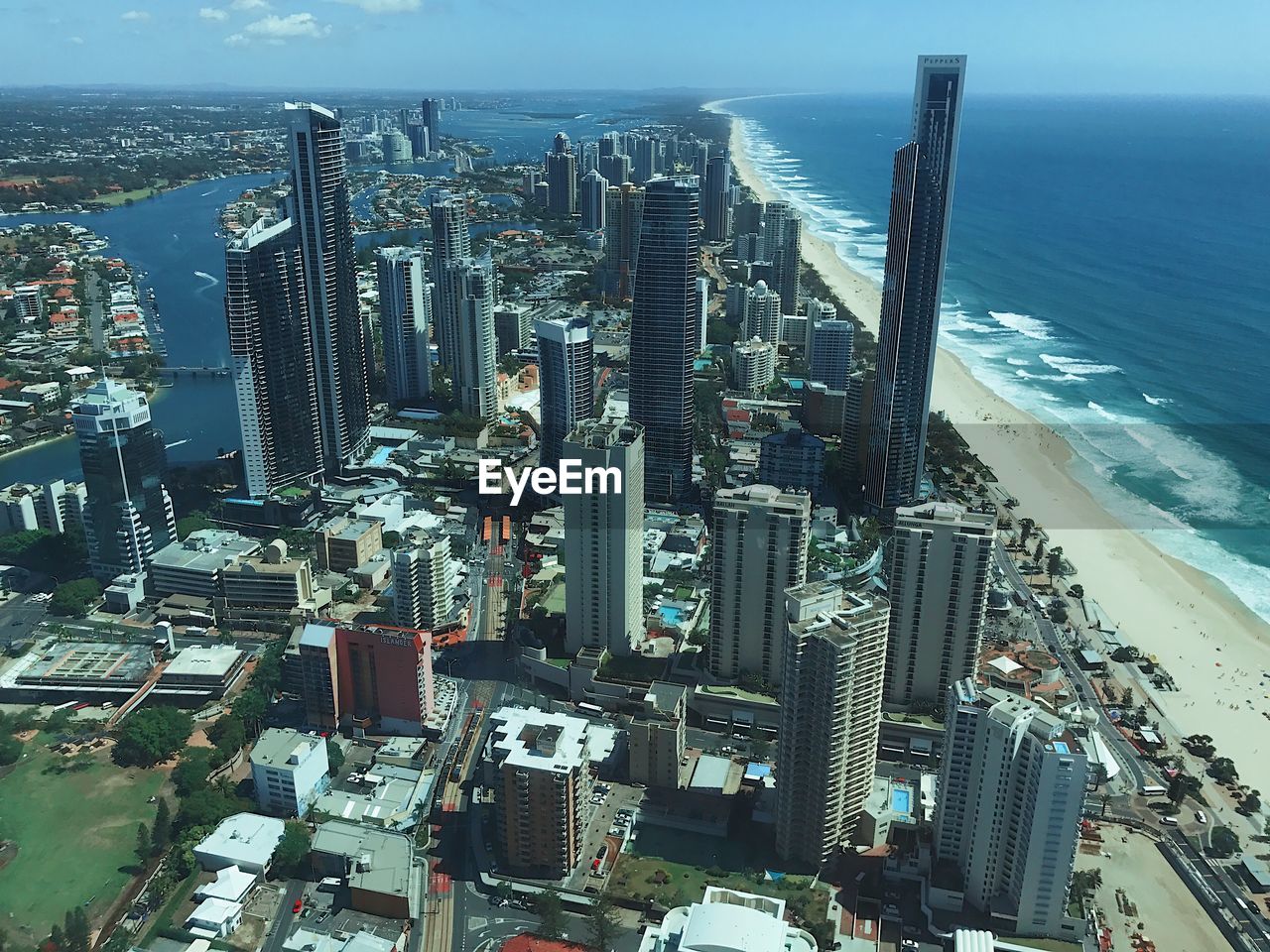 High angle view of modern buildings by sea against sky