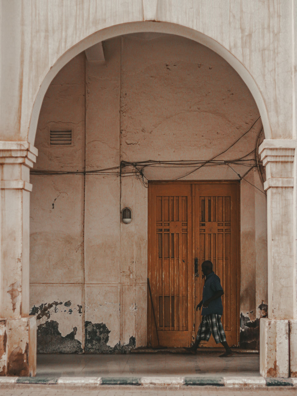 architecture, arch, ancient history, built structure, one person, building exterior, entrance, full length, door, building, adult, history, wood, the past, facade, temple, religion, wall, city, person, day, lifestyles, outdoors, travel destinations