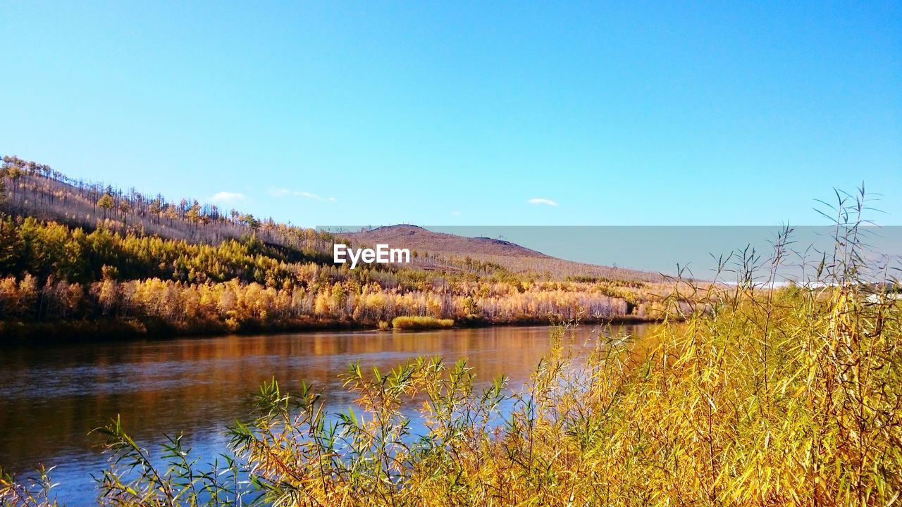 Scenic view of lake by mountains against clear sky