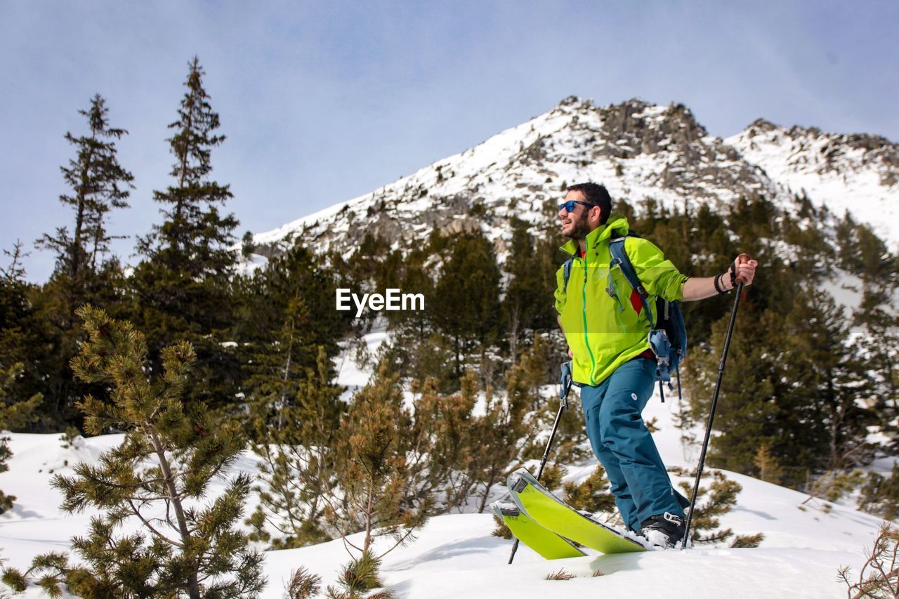 Mid adult man skiing on snowcapped mountain against sky
