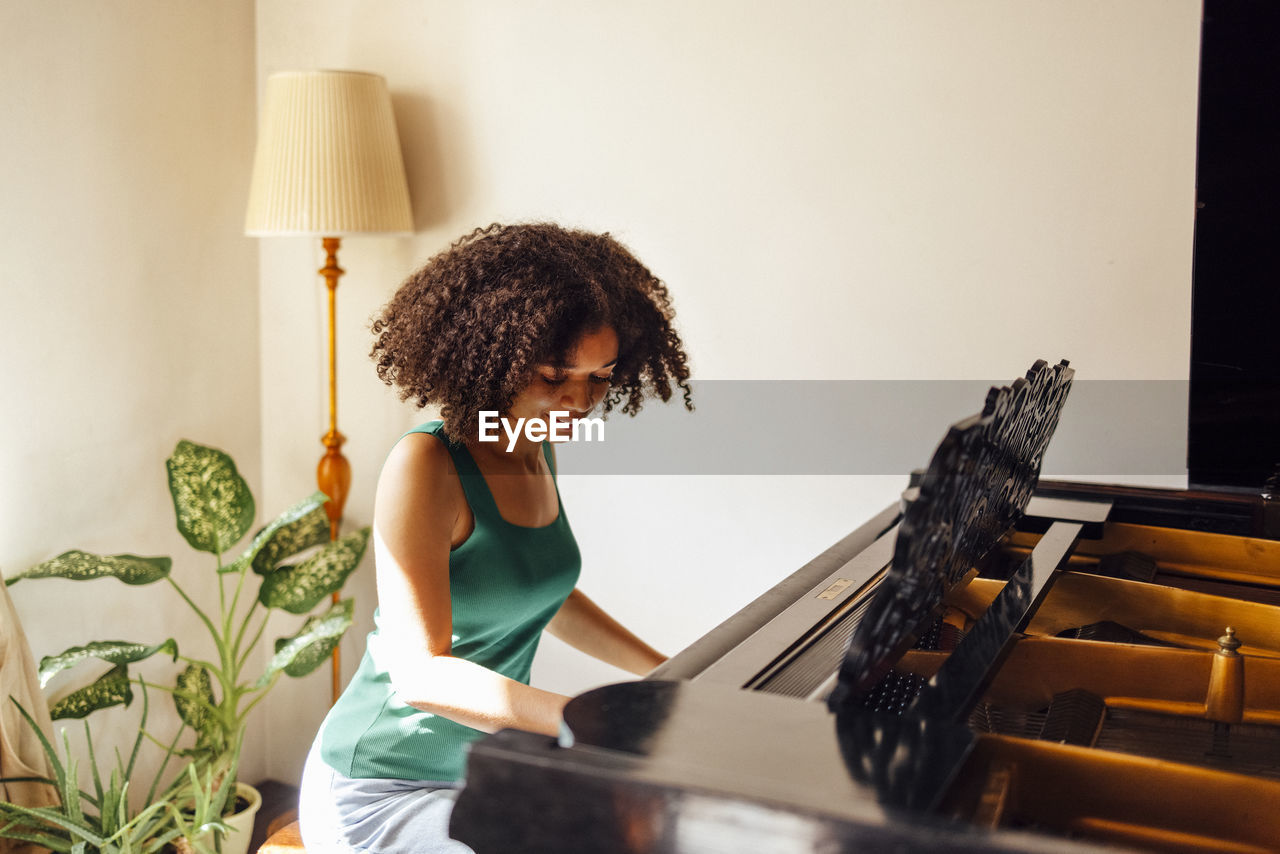 portrait of young woman sitting on bed at home